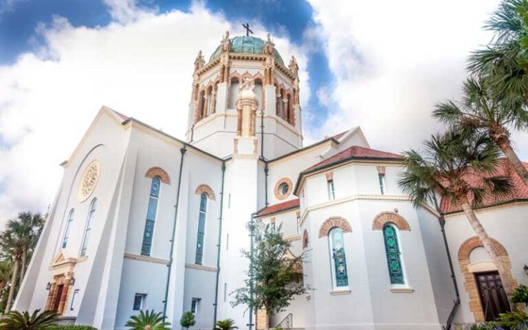 daytime exterior view of white church with narrow arched windows and gothic style tower dome at memorial presbyterian church st augustine