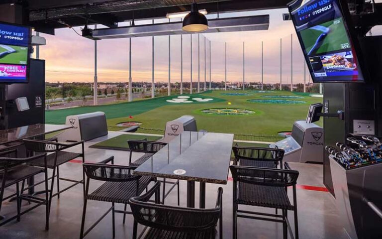 driving bay with tables and clubs at topgolf fort myers
