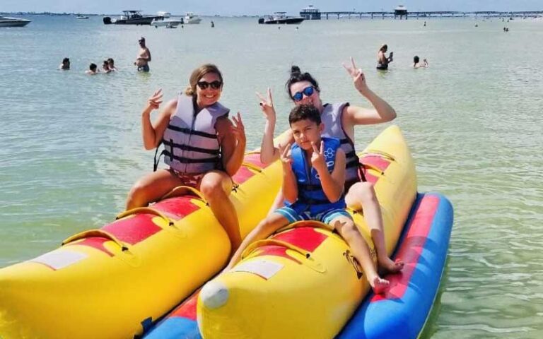 family sitting on banana boats at all island watersports fort myers beach