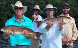 four men holding up caught fish on deck of boat at salty native charters fort myers