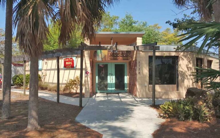 front entrance of building with sign and shady palms at museum of the islands fort myers