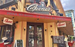 front entrance with sidewalk seating and marquee sign at capones coal fire pizza fort myers