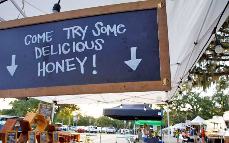 honey vendor with come try some delicious honey sign at st augustine amphitheatre farmers market