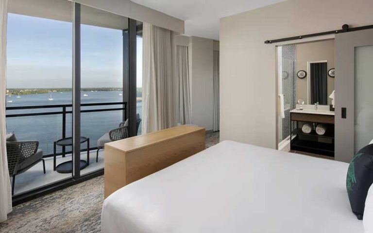 king bed room with balcony view of water at luminary hotel and co fort myers