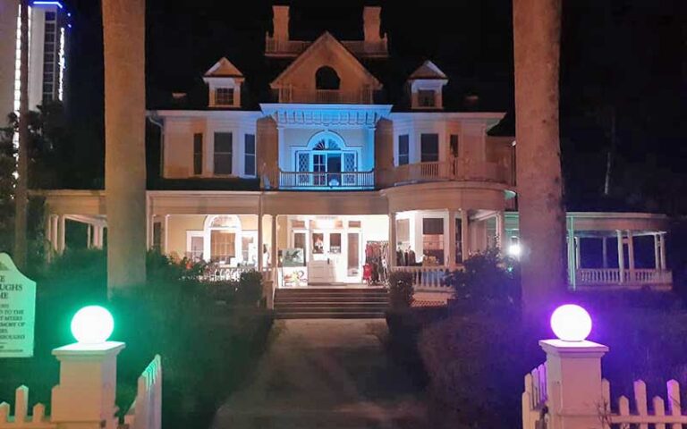 lighted fence gate at night with house in dark for event at burroughs home and gardens fort myers