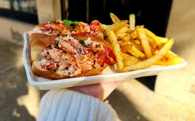 lobster roll on platter with fries on patio at prohibition kitchen st augustine