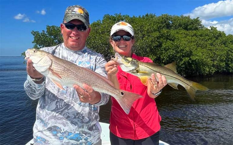 man and woman holding two different long fish at salty native charters fort myers