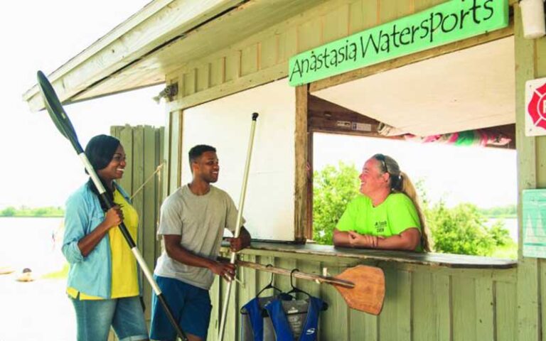 man and woman renting kayak at watersports shop at anastasia state park st augustine