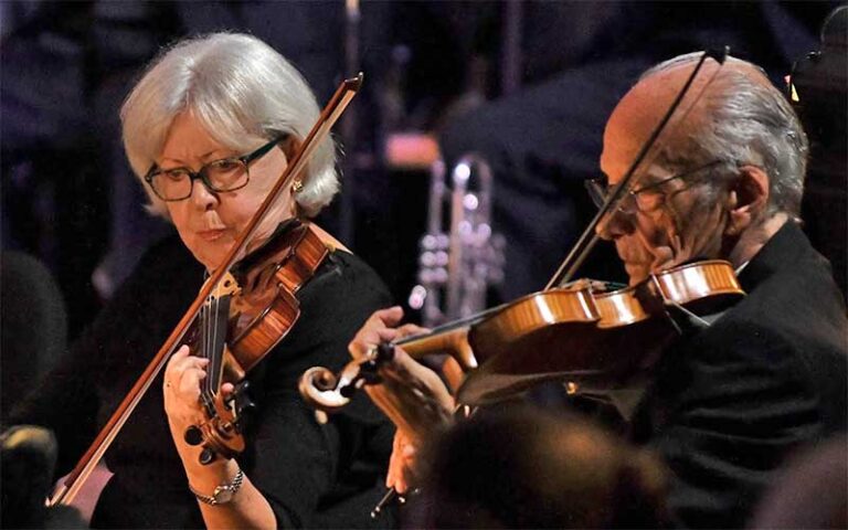 man and woman violinists performing in orchestra at gulf coast symphony fort myers