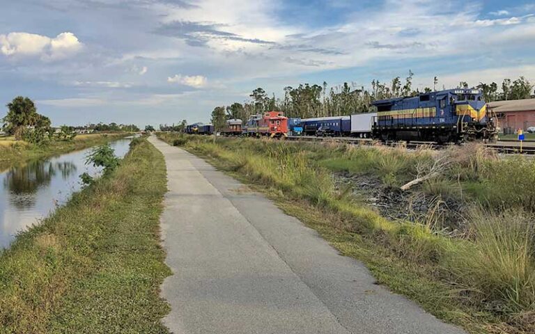 paved path between train on tracks and canal at john yarbrough linear park fort myers