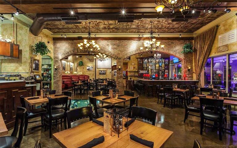 restaurant interior with dining tables and bricked archways at capones coal fire pizza fort myers