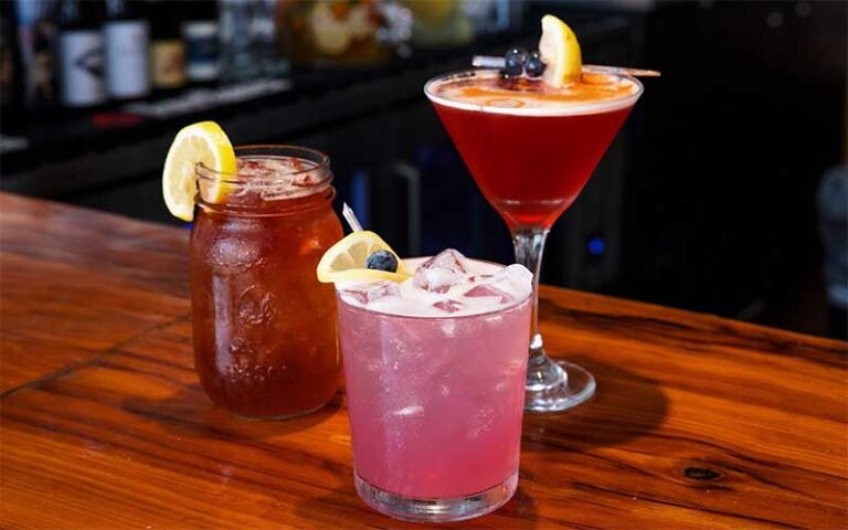 three different cocktails on bartop at the standard restaurant fort myers