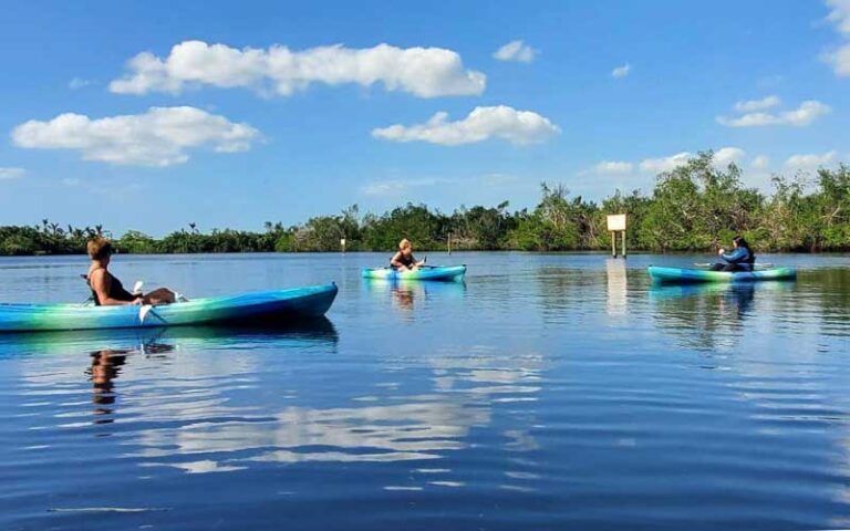 three kayakers on inlet with depth sign at manatee park fort myers