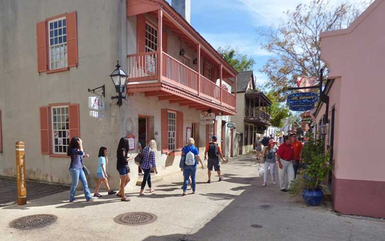 tour group walking along street with salmon colored buildings at st george street st augustine
