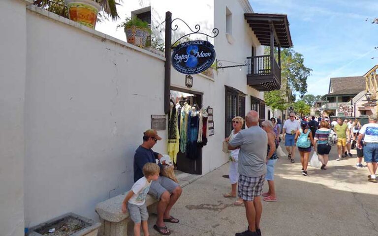 tourists sitting on bench outside gypsy moon boutique at st george street st augustine