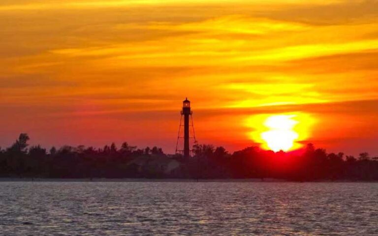 view across dark water of bay island tower with orange sky sunset at adventures in paradise fort myers