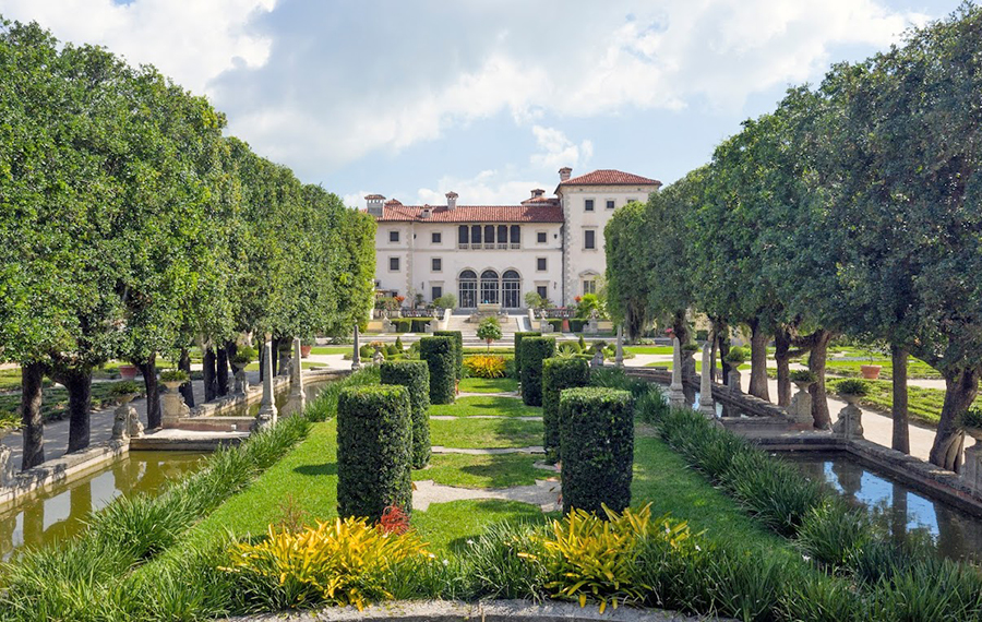 well landscaped garden with squared off trees and mansion in the distance vizcaya museum gardens miami