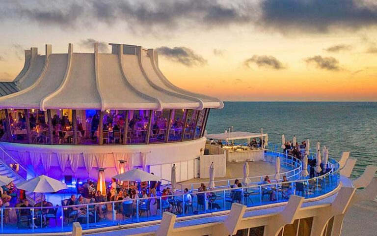 aerial view of round restaurant with crowded terrace and sunset over gulf at spinners rooftop grille st pete beach