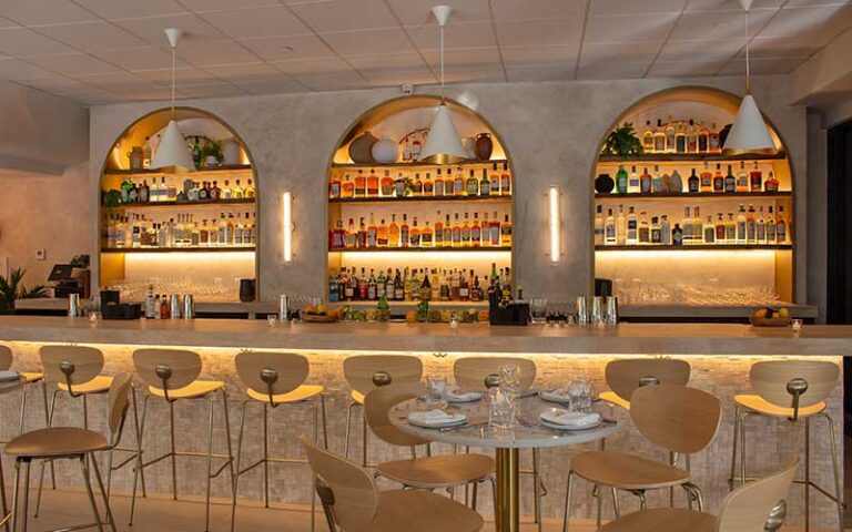 bar with bottles and mediterranean decor at eva and the oyster bar cocowalk miami