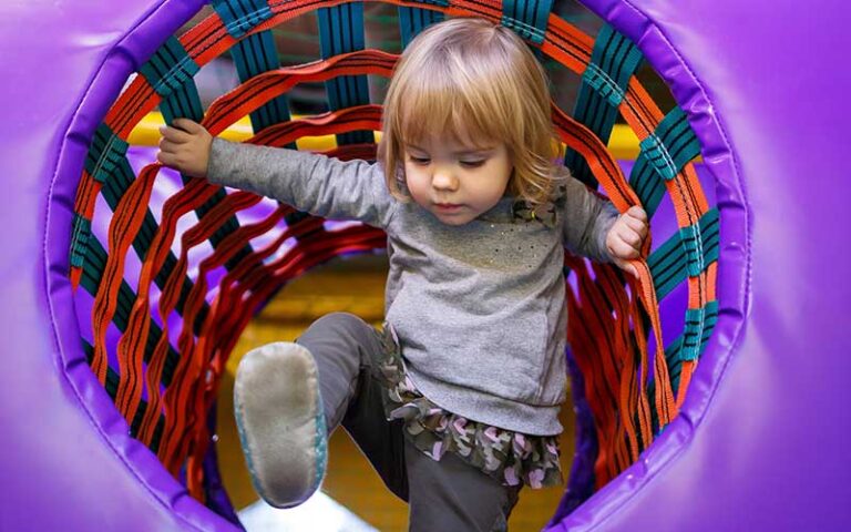 blonde toddler climbs through playground tunnel at happys family fun center fort myers