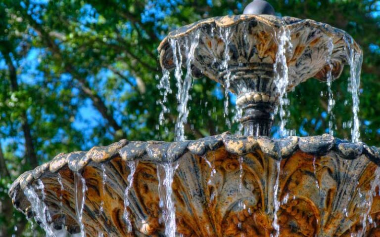 closeup of two tiered bronze fountain with splashing water at hyde park village tampa