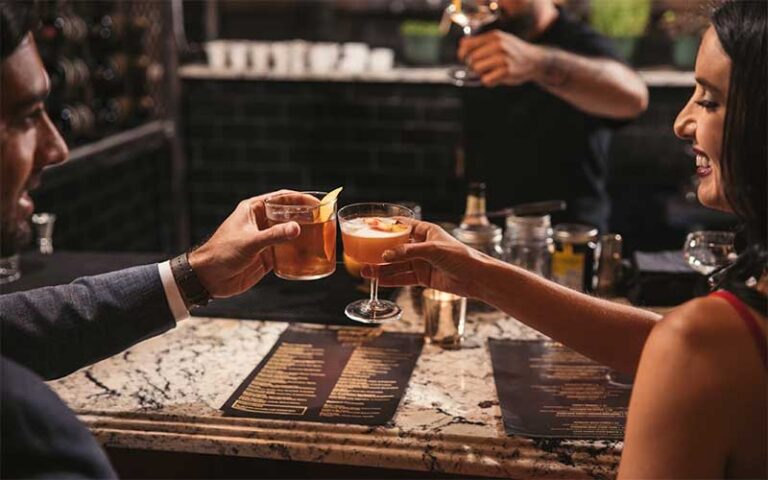 couple toasting drinks at stylish bar restaurant at shops at pembroke gardens ft lauderdale