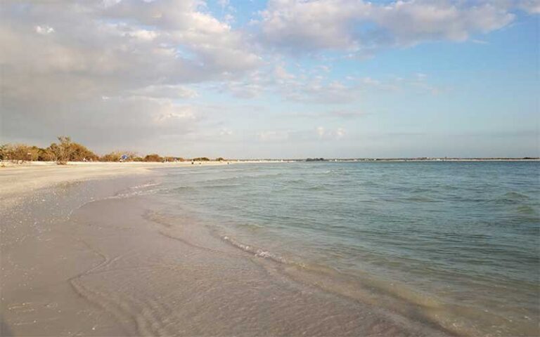 curving beach with cloudy sky at honeymoon island state park dunedin