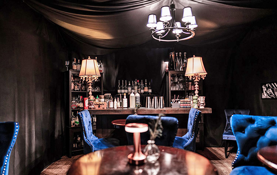 dark lounge with blue seating and bar at room 901 ft lauderdale
