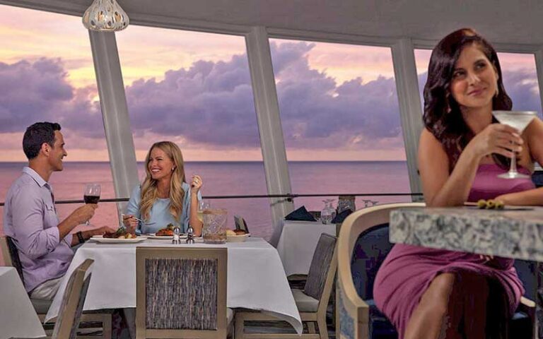 diners in restaurant with floor to ceiling windows with twilight over water at spinners rooftop grille st pete beach