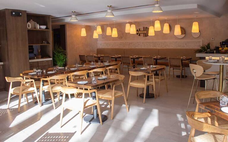 dining room area with sunlight and modern wood design at eva and the oyster bar cocowalk miami