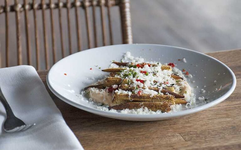 dish at table with baby corn and grated parmesan at oak ola tampa