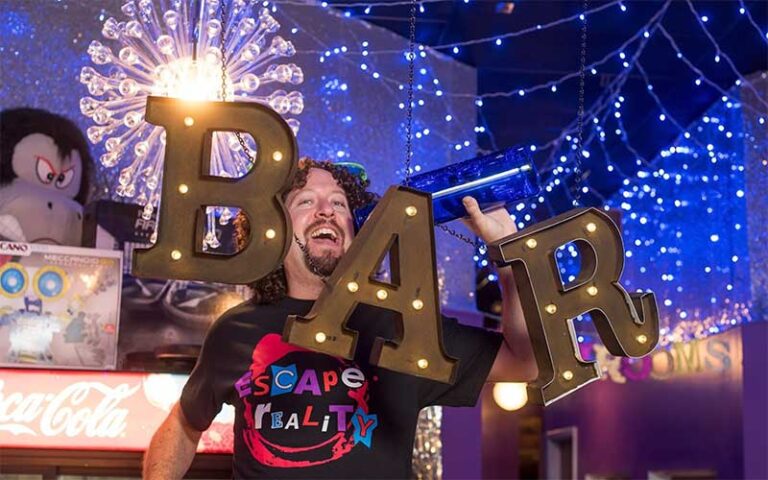 employee laughing posing with sign at escape reality sarasota