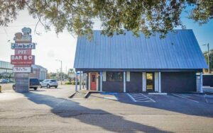 exterior of diner with roadside sign and parking lot at jimbos pit bar b q tampa