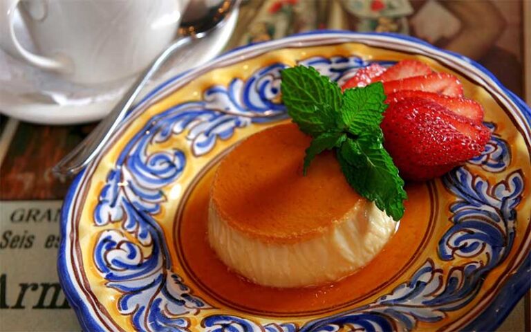 flan with strawberries on ornate dish with cup and saucer at columbia restaurant ybor city tampa