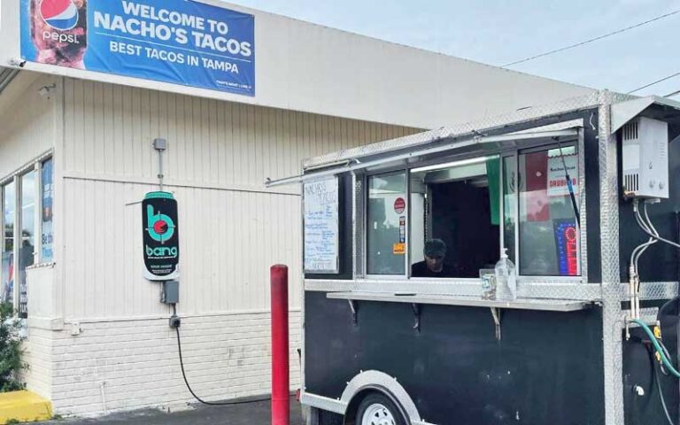 food truck next to building with banner sign at nachos tacos tampa