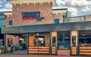 front exterior of restaurant with brick and wood at whiskey cake tampa