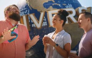 guide talking to couple in front of universal orlando resort globe landmark