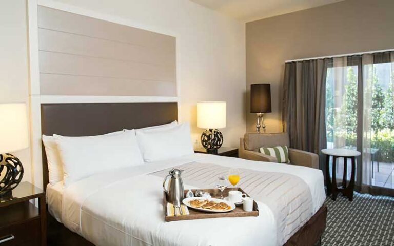 king size bed guestroom with breakfast tray and view at epicurean hotel autograph collection tampa