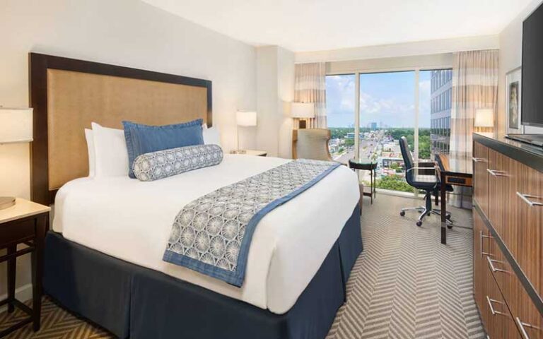 king size bed guestroom with city view at the westshore grand tampa