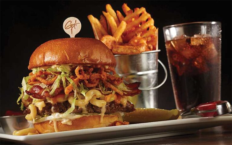 large burger with onions fries and soda at planet hollywood disney springs