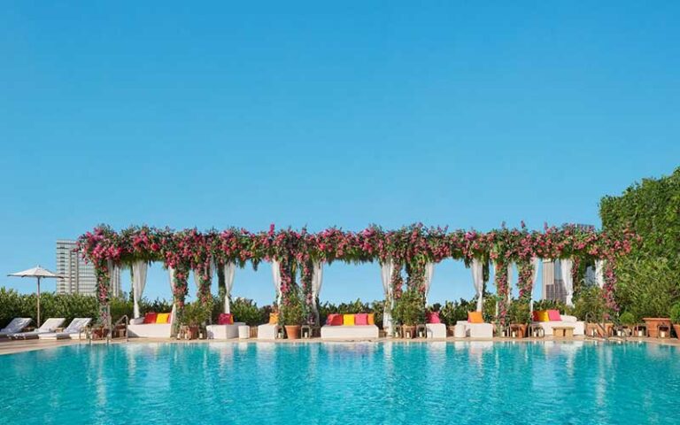 large pool with red flowered pergola along side at the tampa edition