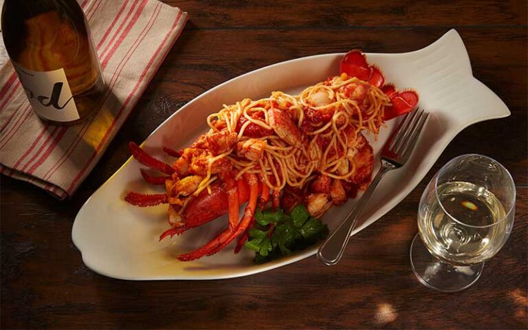 lobster pasta in fish shaped dish with wine at planet hollywood disney springs