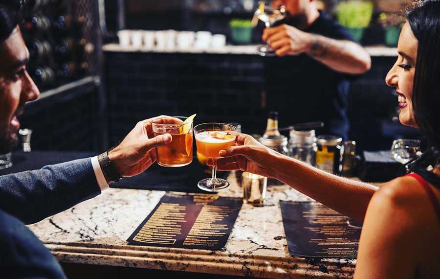 man and woman toasting cocktails at unit b eatery and spirits ft lauderdale