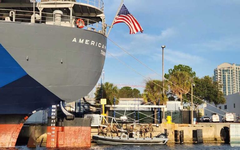 merchant marines on boat behind ship along dock at american victory ship museum tampa