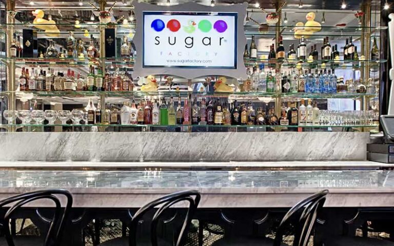 mirrored bar with stools and brand bottles at sugar factory icon park orlando