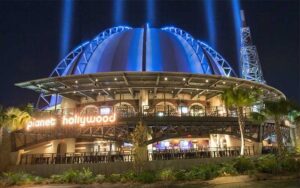 night exterior of globe shaped restaurant with spotlights at planet hollywood disney springs