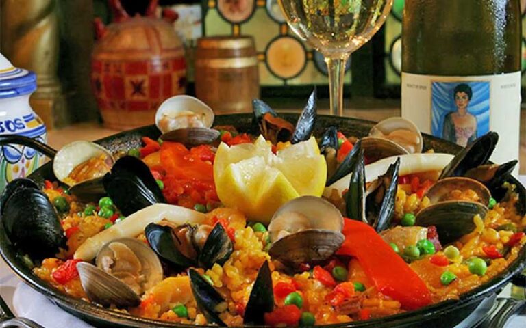 paella dish with clams and mussels next to wine bottle at columbia restaurant ybor city tampa