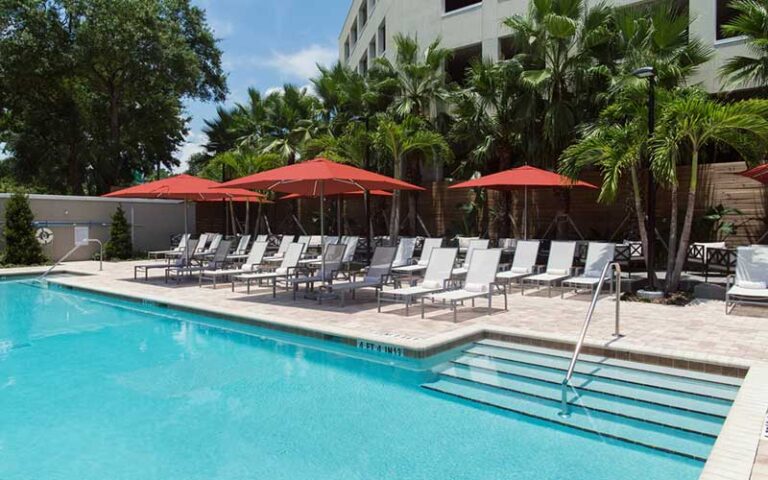 pool terrace with red umbrellas and lounge chairs at epicurean hotel autograph collection tampa