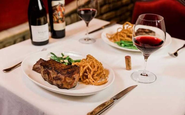 table place setting for two with wine and steak entrees at berns steak house tampa