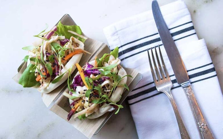 two bao buns with lettuce and knife fork napkin at on swann tampa